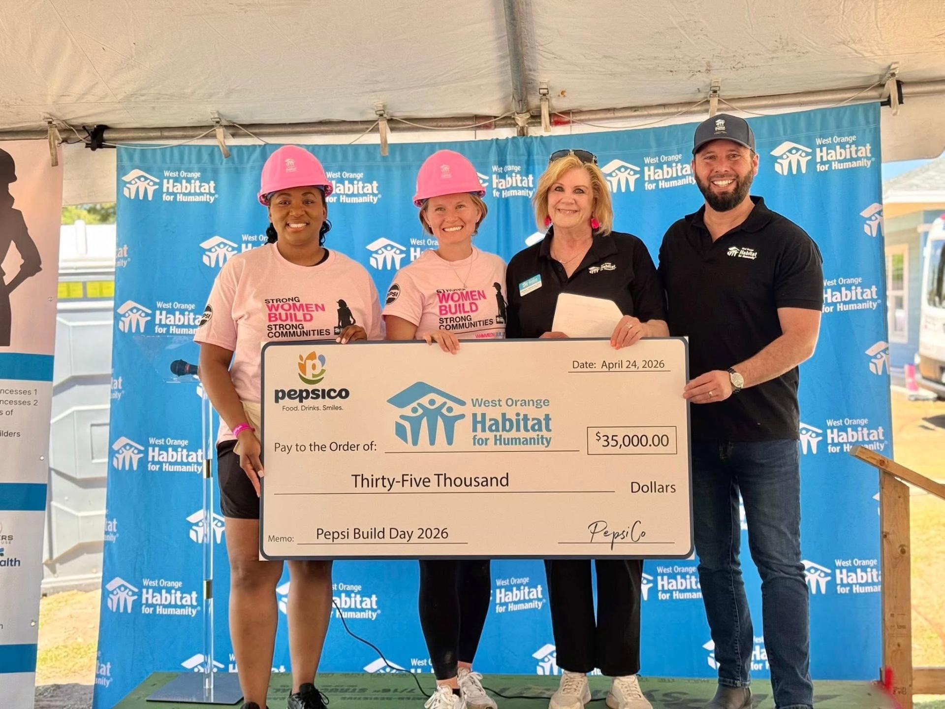 Austin Arthur accepting a $35,000 check from PepsiCo for West Orange Habitat for Humanity