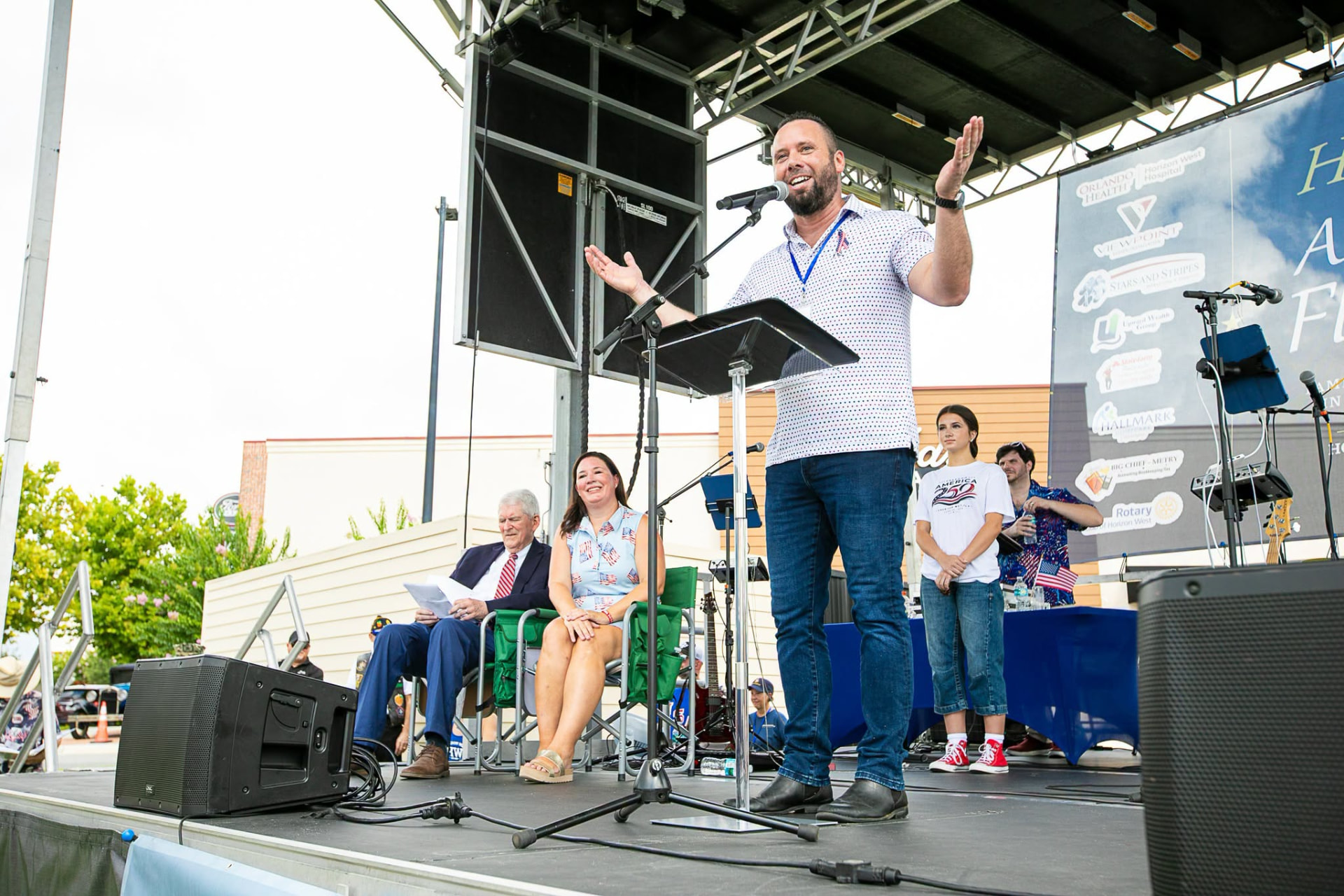 Austin Arthur speaking from the stage at the Hamlin All-American Flag Parade