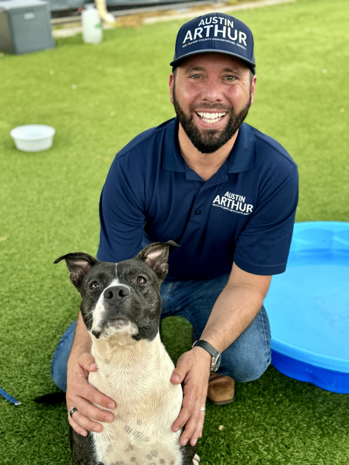 Austin Arthur kneeling with a dog during a community animal welfare event