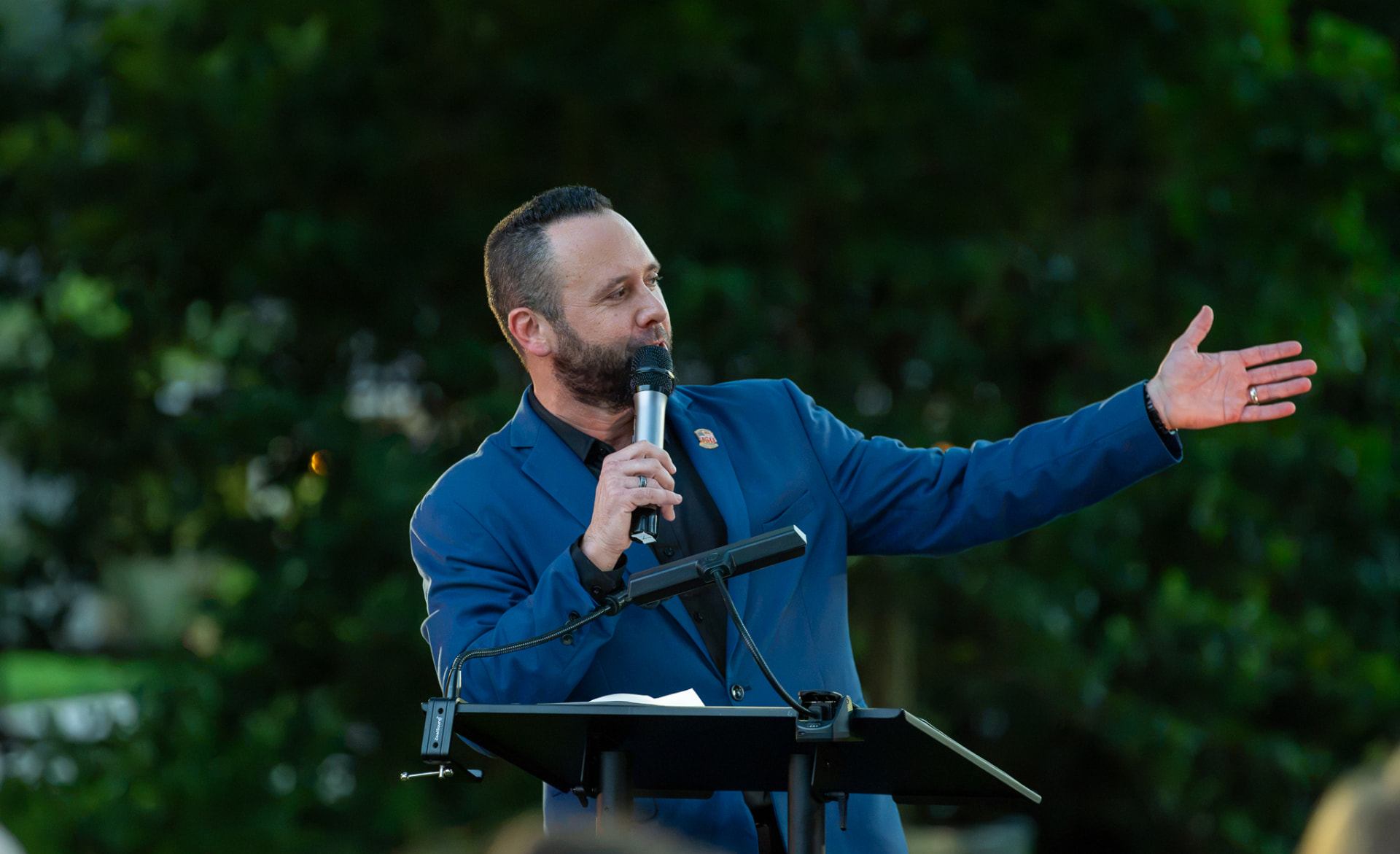 Austin Arthur speaking from the podium during Rise Up: America 250 in Motion in Windermere, Florida
