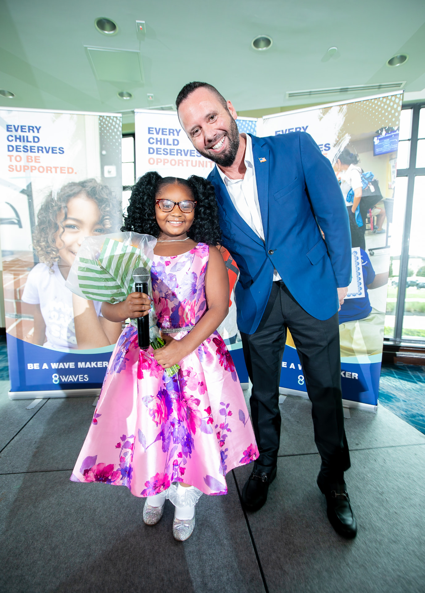 Austin Arthur with a young honoree at the 2026 8 Waves WaveMaker Luncheon benefiting the I AM Children's Museum