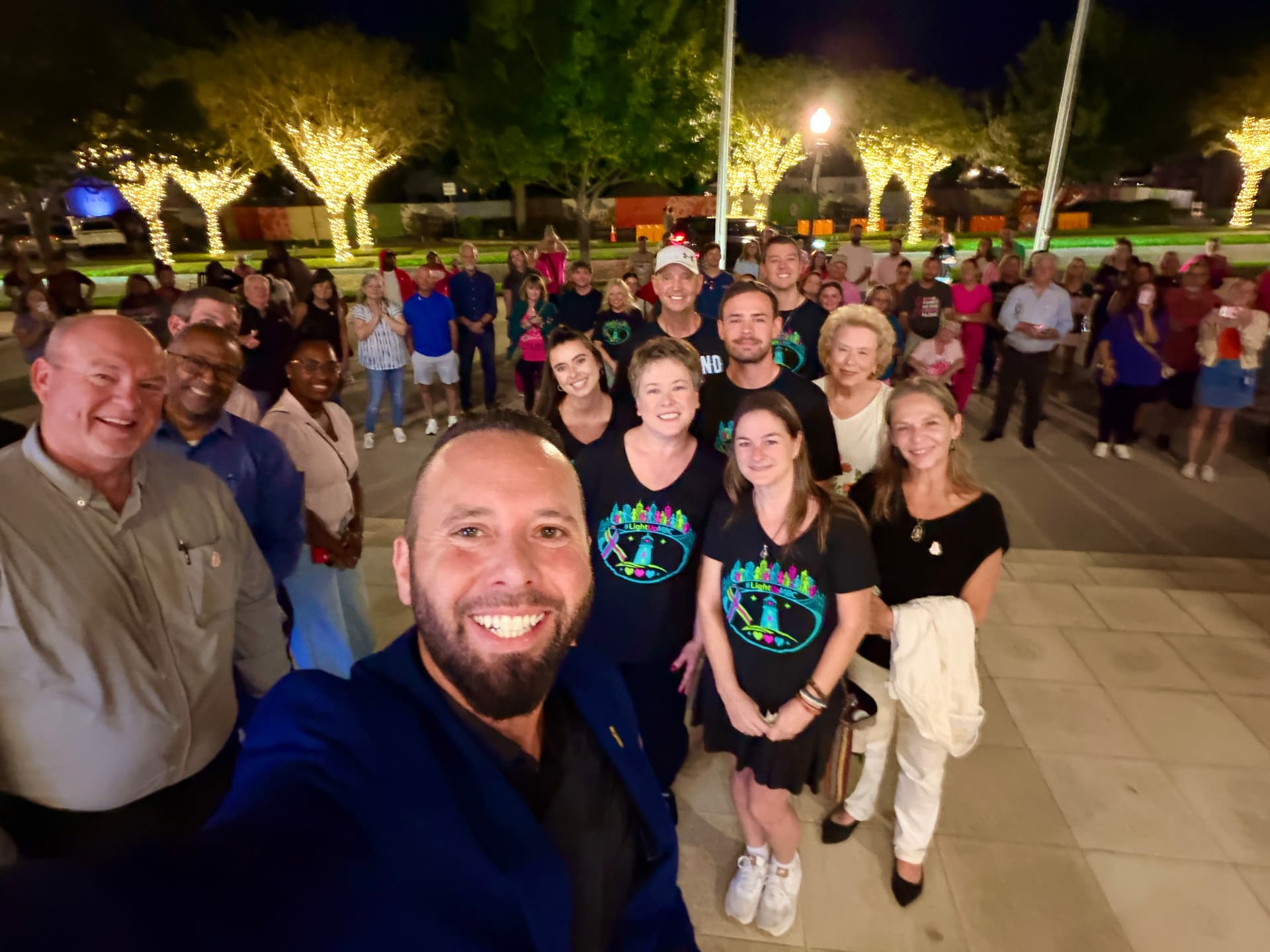 Austin Arthur and volunteers wearing #LightUpMBC event shirts at a metastatic breast cancer awareness gathering in Winter Garden, Florida
