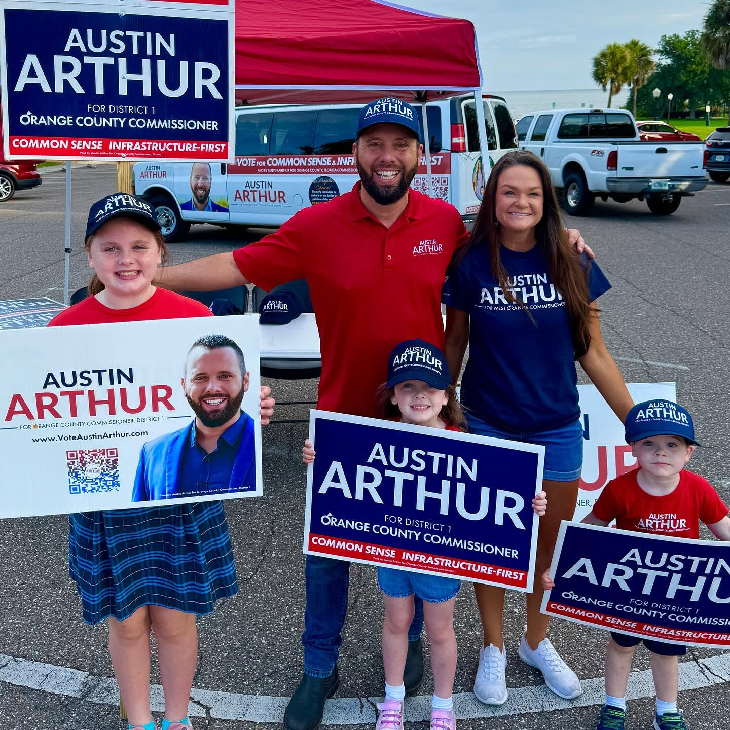 Austin and Kellie Arthur with their children at a campaign tent on the lakefront
