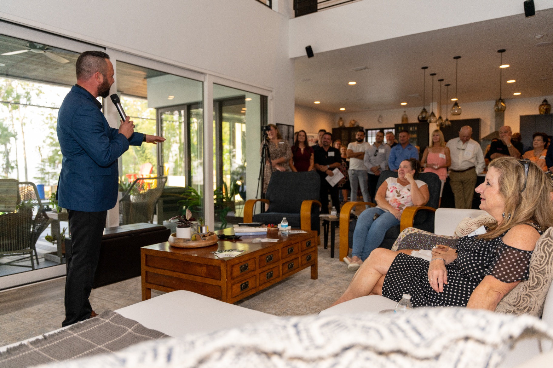 Austin Arthur addressing a full living room of neighbors during a home meet-and-greet