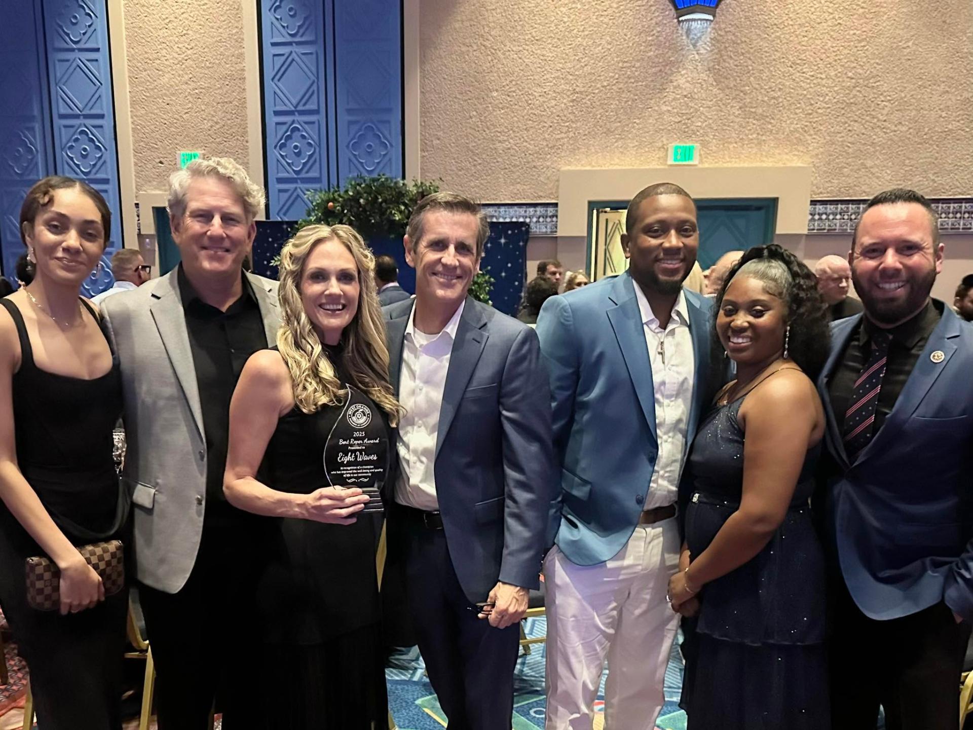 Austin Arthur with the 8 Waves Children and Family Services team at an awards event